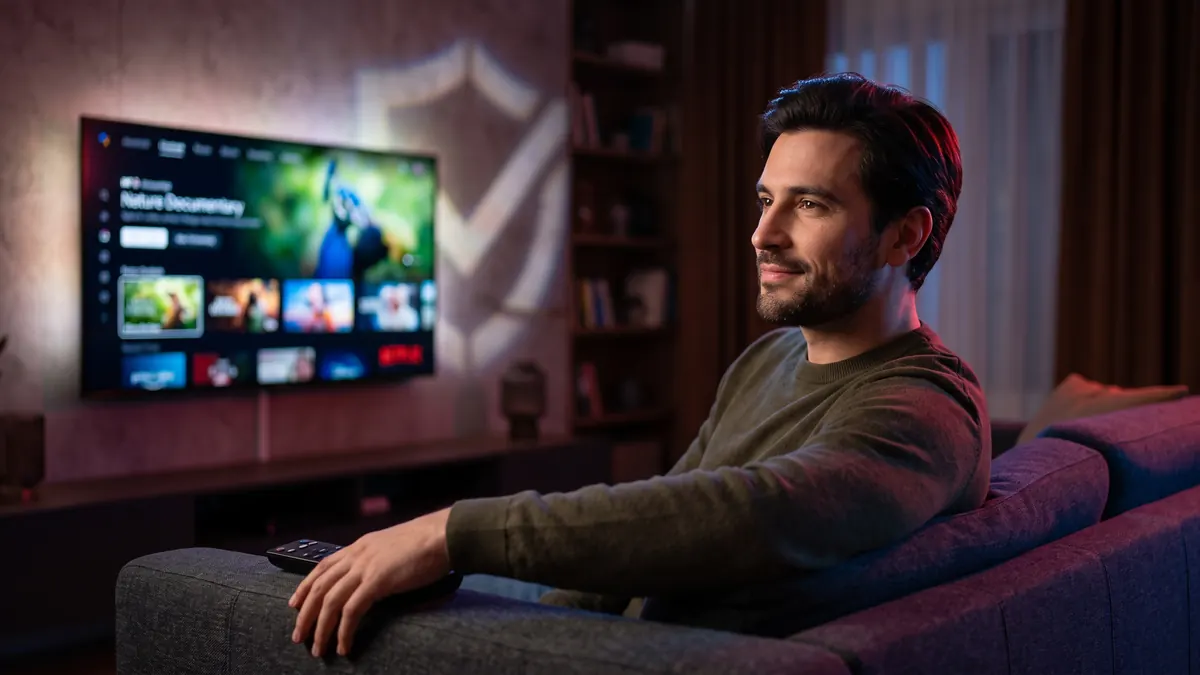Homme détendu regardant le meilleur IPTV sur un grand écran